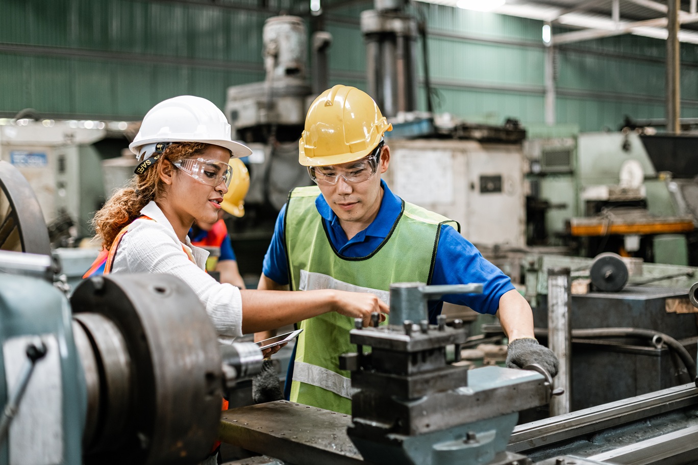 Pessoas em fábrica trabalhando com insalubridade no trabalho.