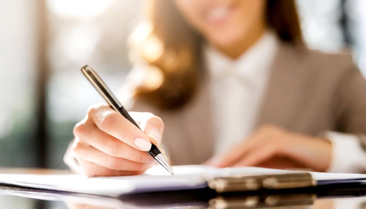 Pessoa assinando contrato conforme seu regime de trabalho.